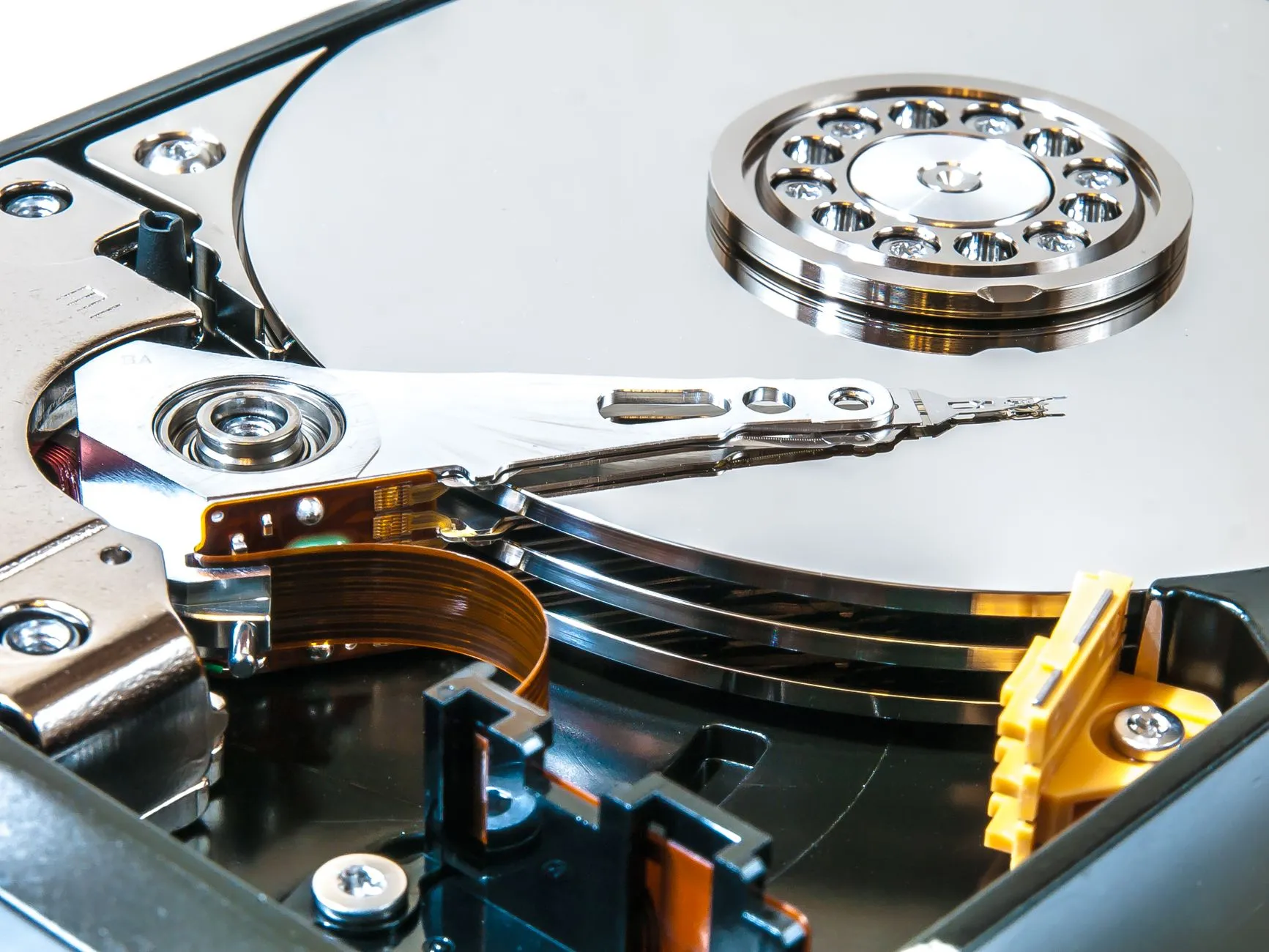 The inside of a hard drive, its platter and read arm exposed