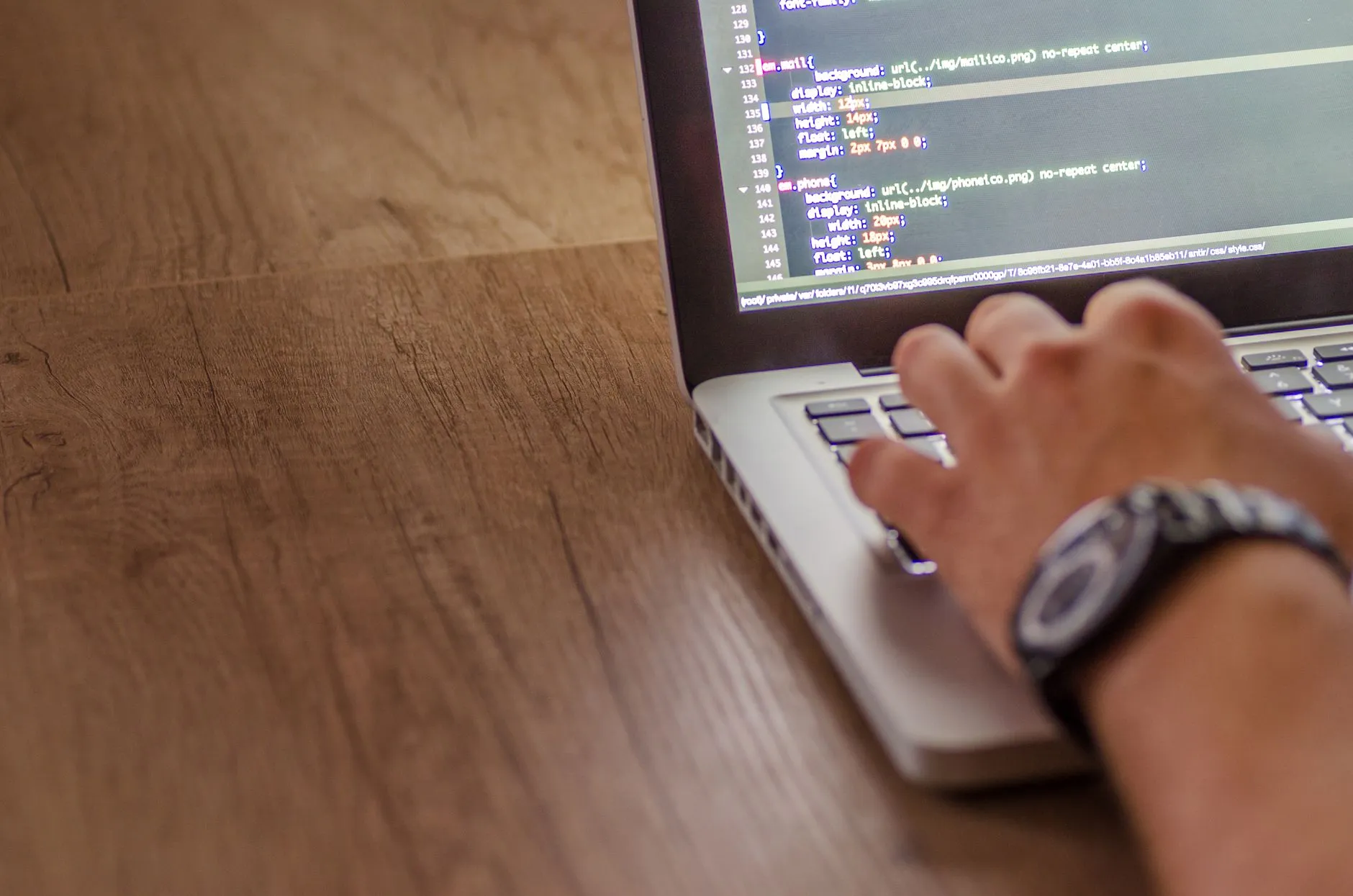 Developer editing website styling code on a laptop
