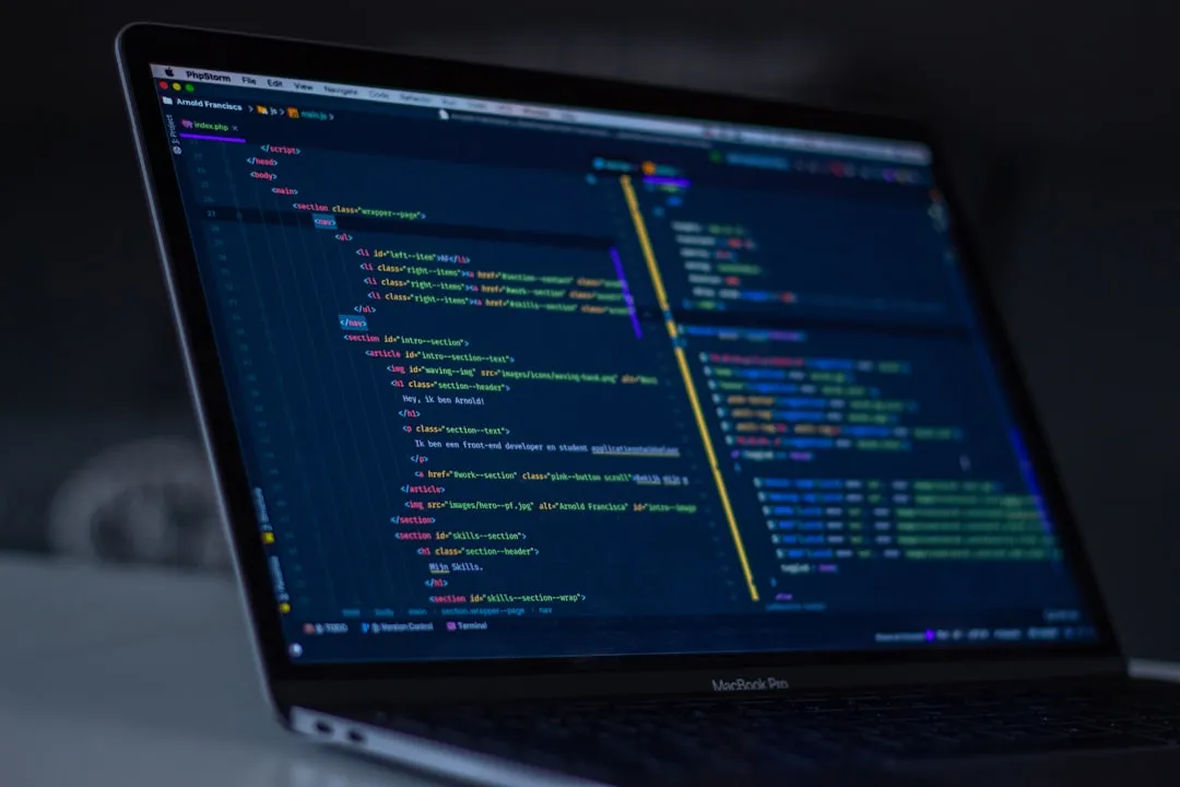 A code editor open on a laptop, showing the HTML of a site under construction