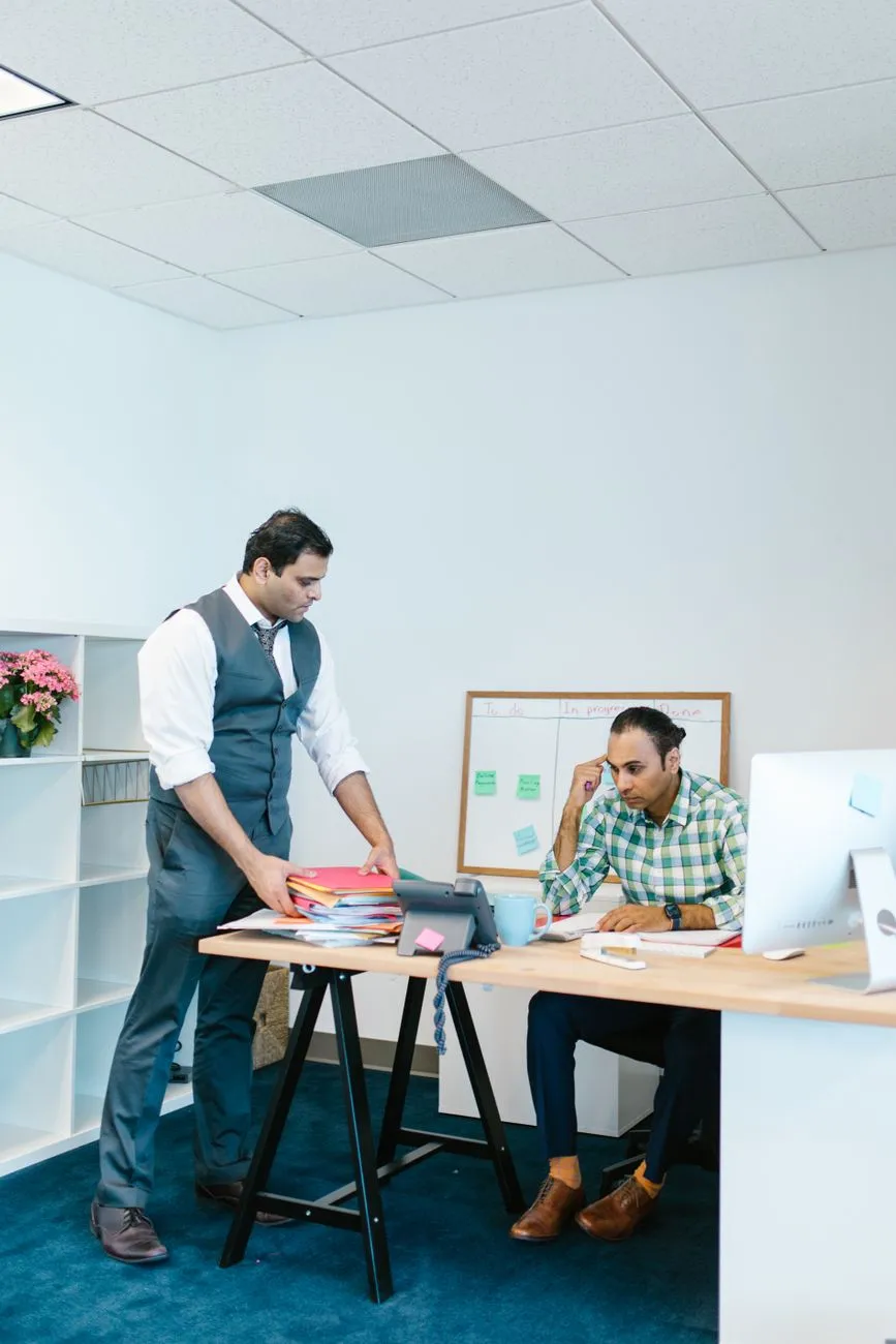 Two colleagues at a desk in a professional office workspace
