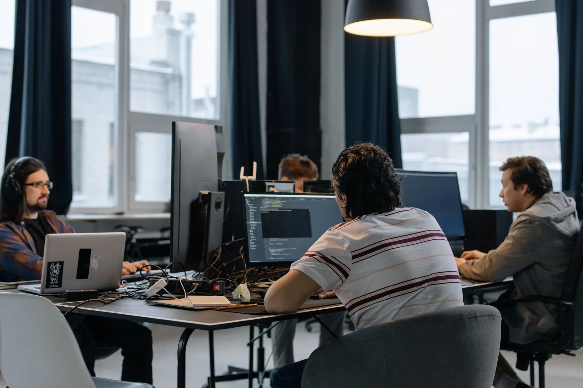 A software engineering team at workstations with code open on the monitors