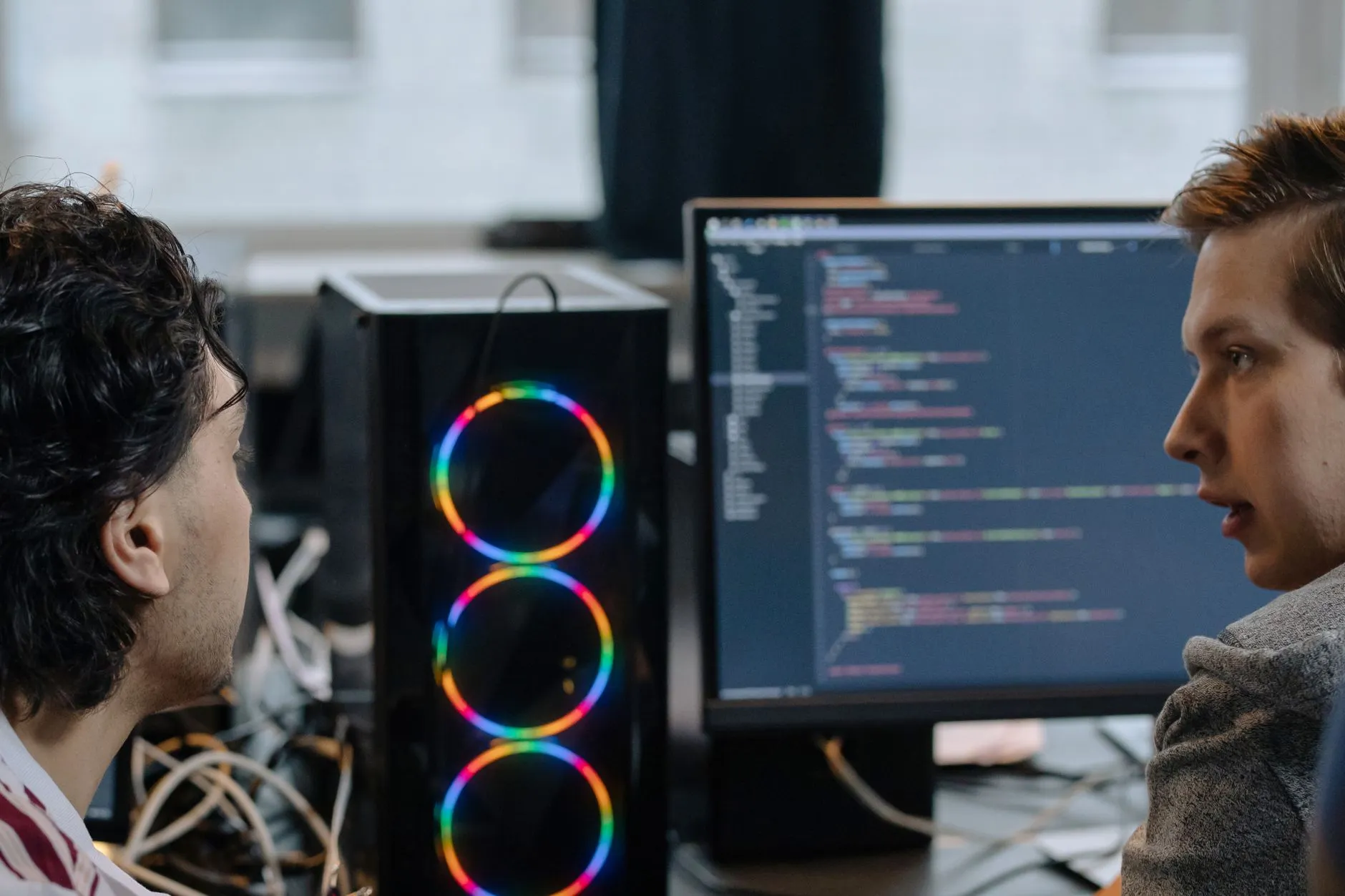 Two engineers reviewing code together on a monitor