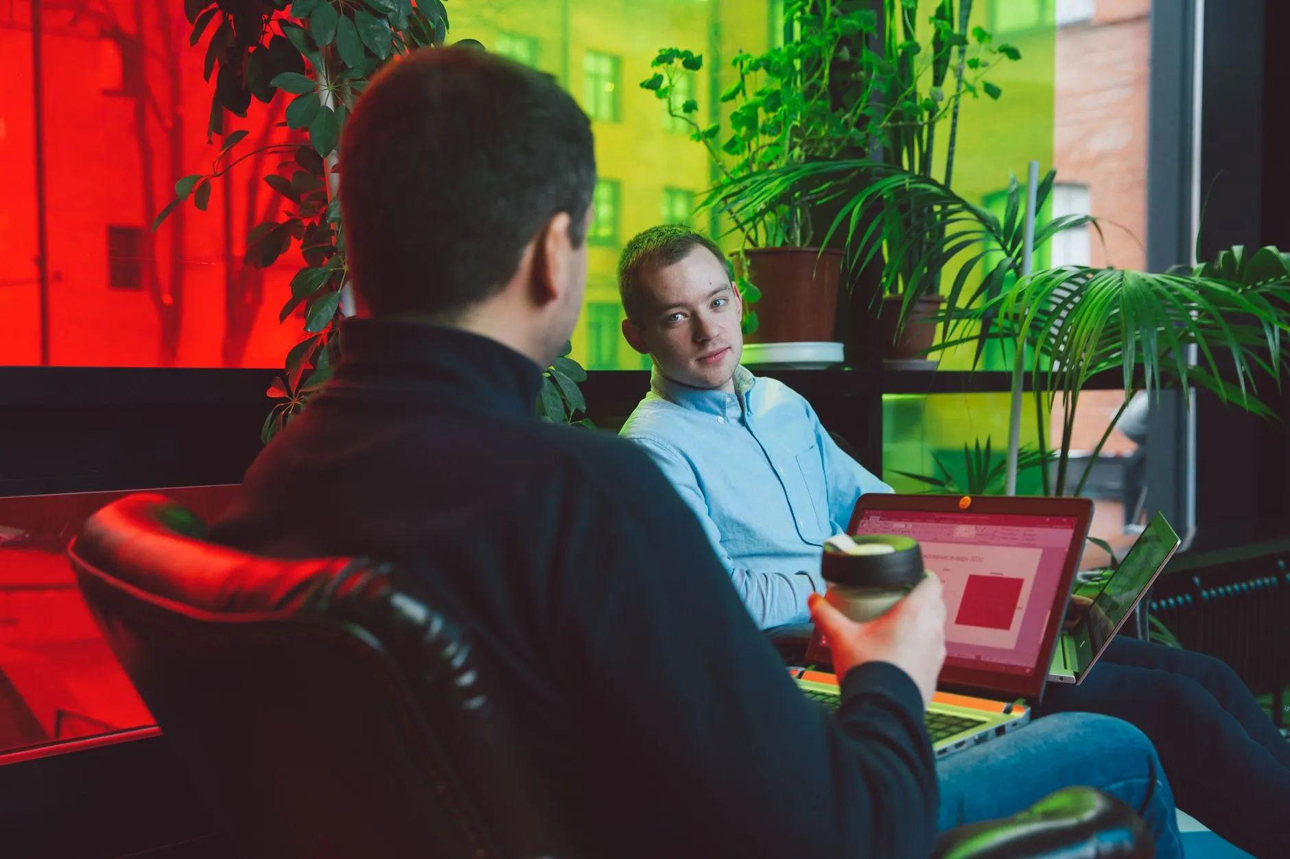 Two colleagues discussing options together at a laptop