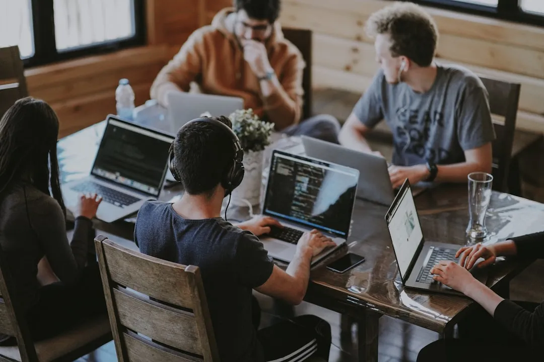 A web development team working on laptops around a shared table