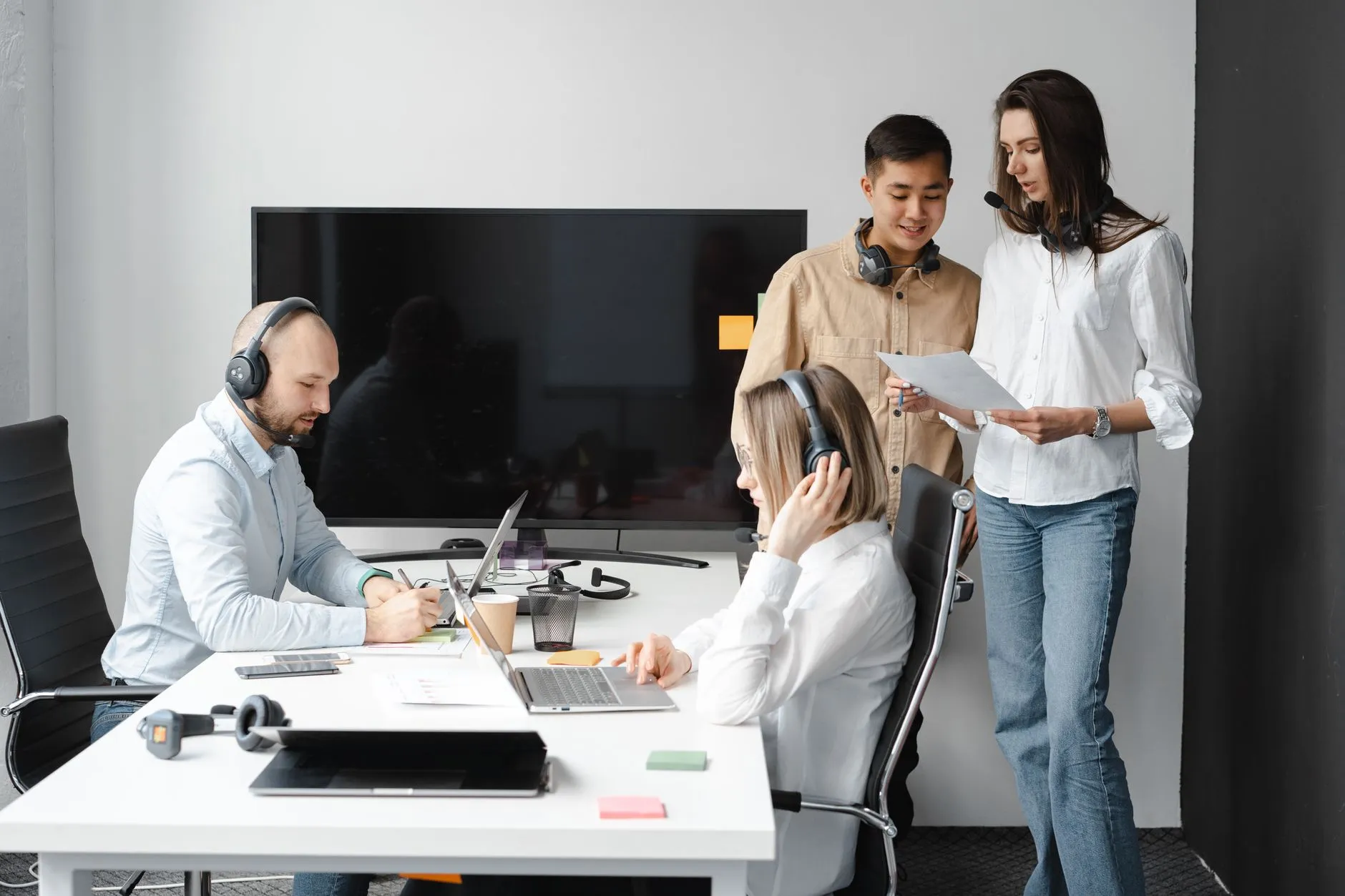 A website operations team working together at laptops in an office